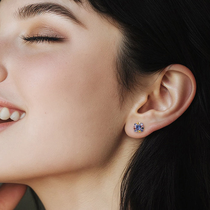 Round stud earrings on ear, gold-tone setting with multicolor sapphire halo and lavender center