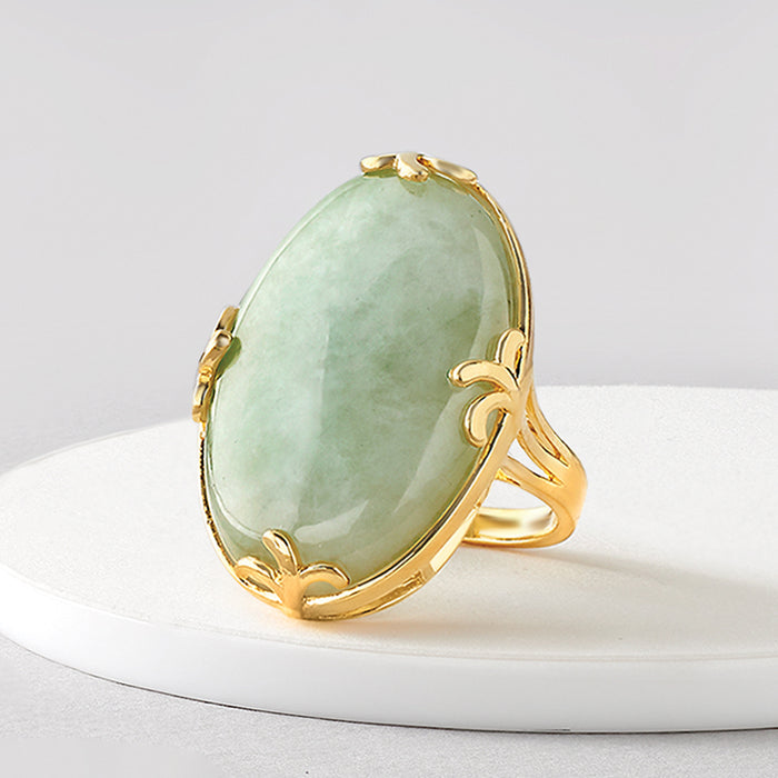 Oval jade ring with gold-tone leaf accents along the band