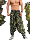 Man wearing camouflage harem pants with a forest background