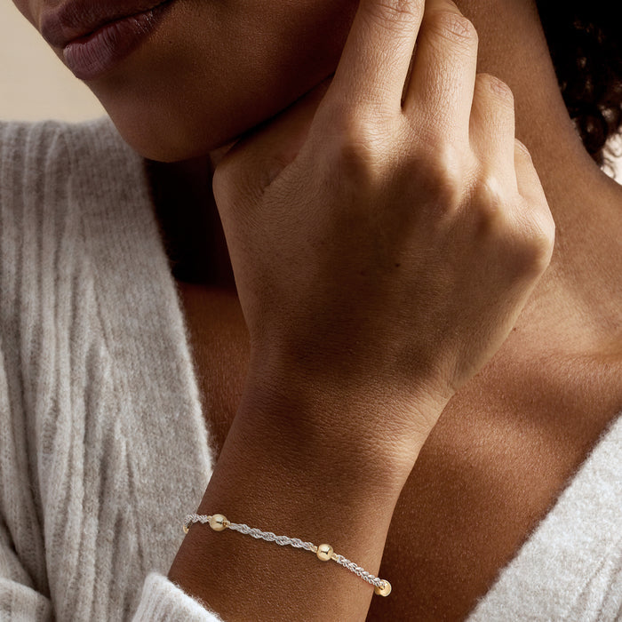 Gold and silver bead rope-chain bracelet worn on wrist