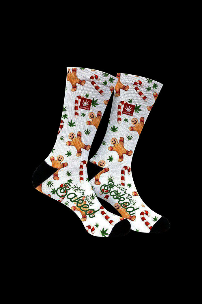 Knee-high socks with a festive, cannabis-themed pattern featuring gingerbread men and marijuana leaves, reading "Let's Get Baked".